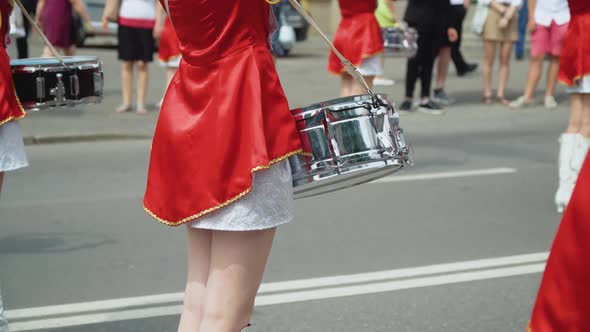 Street Performance of Festive March of Drummers Girls in Red Costumes on City Street alt