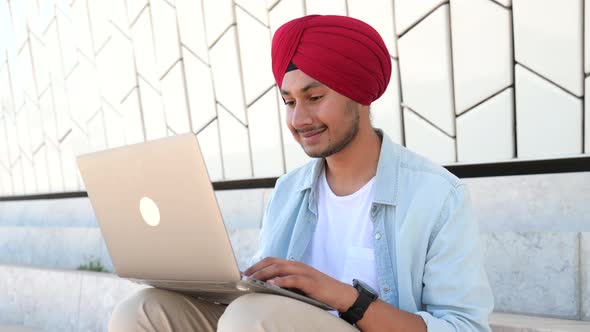 Indian Freelancer Man in Traditional Turban Sitting Outdoors with Laptop