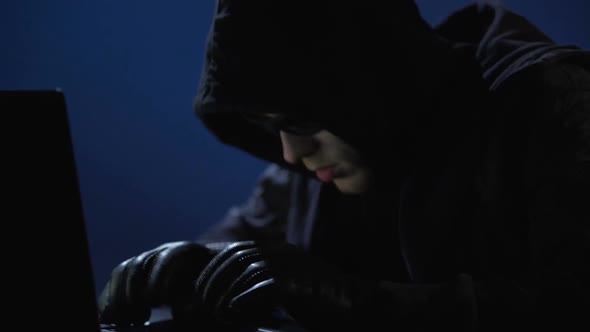 Strange Man in Black Clothes, Sunglasses and Gloves Stealing Data From Laptop alt