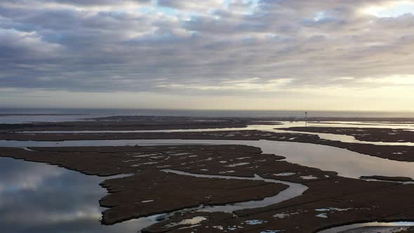 An aerial view over Baldwin Bay near Freeport, NY during sunset. The camera pan & truck left high ov alt