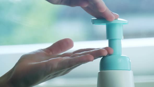 Children's Hands Push the Dispenser and Squeeze Out Liquid Soap