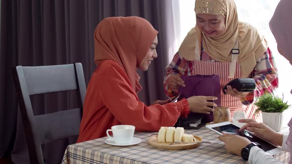 Young muslim woman use smartphone contactless payment in coffee shop