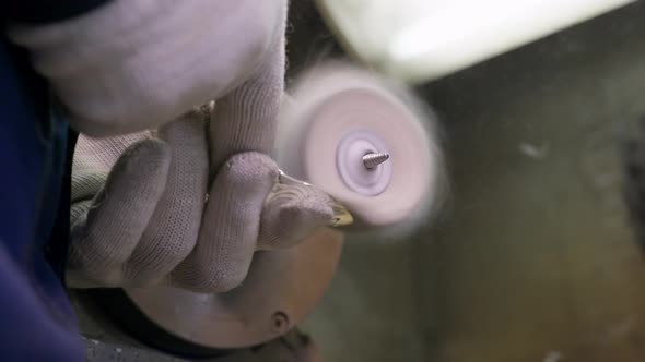 Close Up at the Worker Burnishing the Finished Silver Spoon with a Machinetool at the Plant for alt