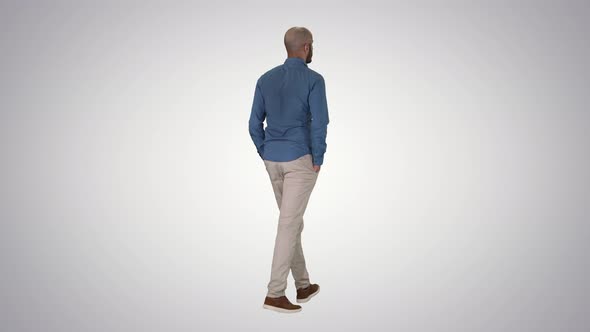 Casual Young Man Walking on Gradient Background. alt