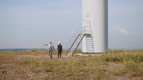 African American Inspector in Black Suit and White Helmet Talking with Indian alt