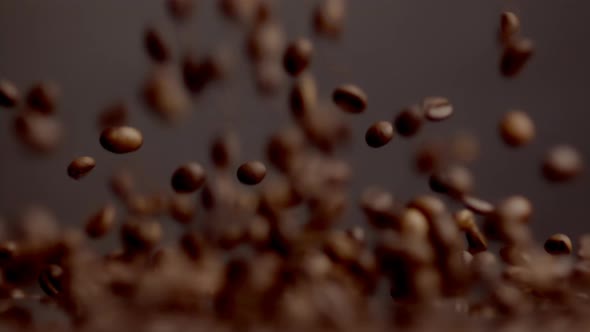 Roasted Coffee Beans Pouring on Table Bouncing Close Up alt