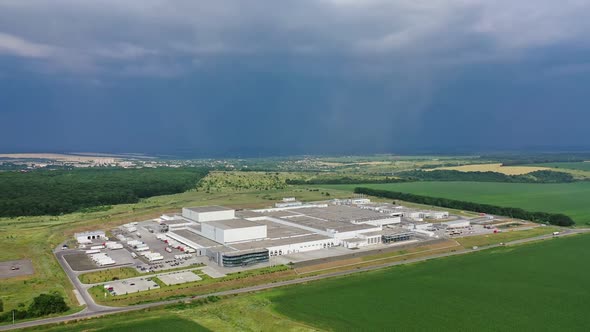 Birds-eye view to the modern industrial buildings. Large manufacturing plant under the blue sky alt