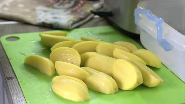Mans Hands Cut Potatoes and Onion with the Knife in the Kitchen Closeup alt