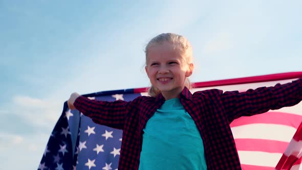 Blonde Girl Waving National USA Flag Outdoors Over Blue Sky at Summer American Flag Country alt