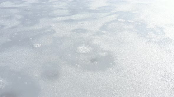 Slow flying over crystallized lake surface by winter 4K drone footage alt