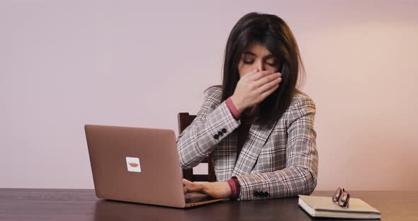 Atractive Brunette Woman Working at Home on Laptop Computer Sneeze and Close Her Mouth with Hand