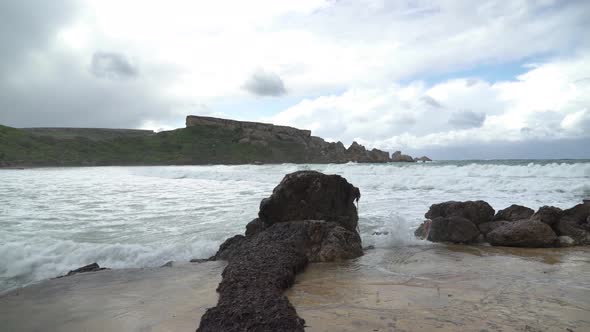 Algae Grows on Stone near Ghajn Tuffieha Bay Shore with Sea Waves Crashing and Splashing alt