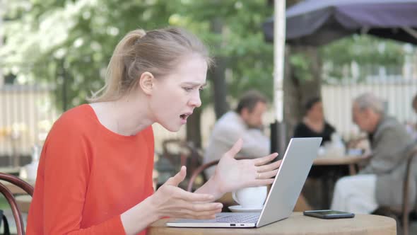 Young Woman Frustrated By Failure Sitting in Cafe Terrace alt