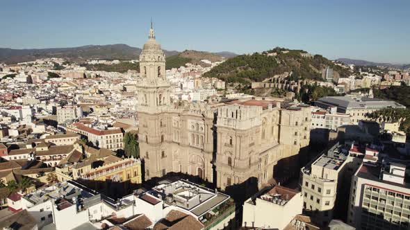 Aerial forward view of cathedral surrounded by the city. Malaga. Spain