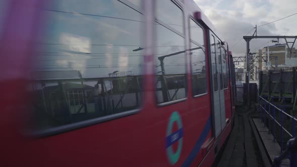 London DLR train is passing by  in a cloudy day alt