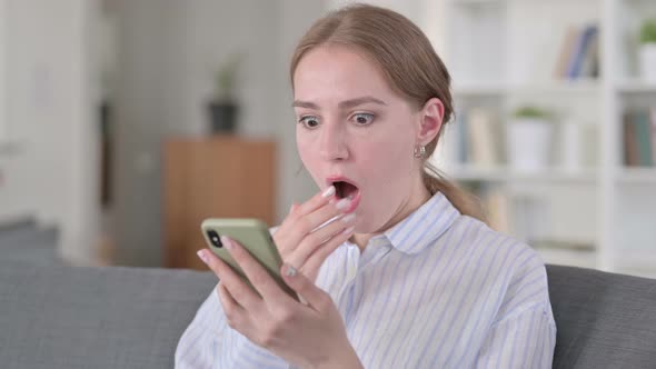 Portrait of Young Woman Reacting To Loss on Smartphone alt