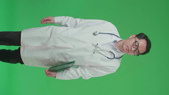 The Front View Of Asian Doctor With Stethoscope Holding Document File While Walking On Green Screen alt
