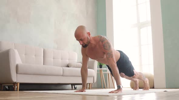 Athletic Young Shirtless Man in Shorts Doing Push-ups in Living Room at Home.