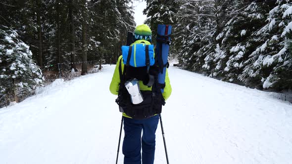 Man with outdoor backpack walking in the mountains in winter. Winter mountain trekking.