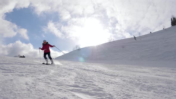 Mountain Skier Skiing On Snowy Mountainside In Resort On Sunny Day At Winter alt