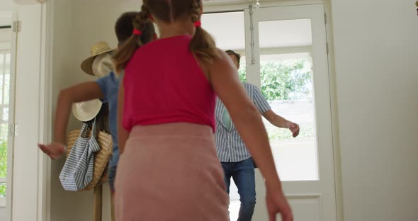 Caucasian happy son and daughter running to father coming home, embracing and welcoming alt