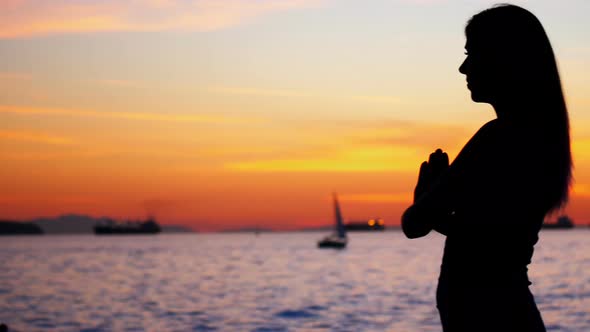 Woman performing yoga on the beach alt