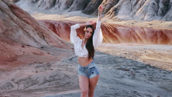 Beautiful woman posing on other-worldly hilly landscape