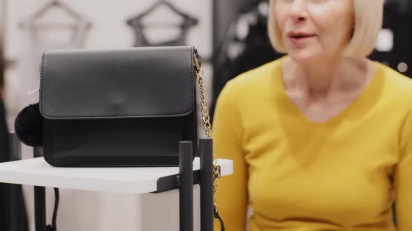 Mature Woman Shopper in Boutique Chooses Goods Looking with Surprise Amazing at Elegant Fashionable alt