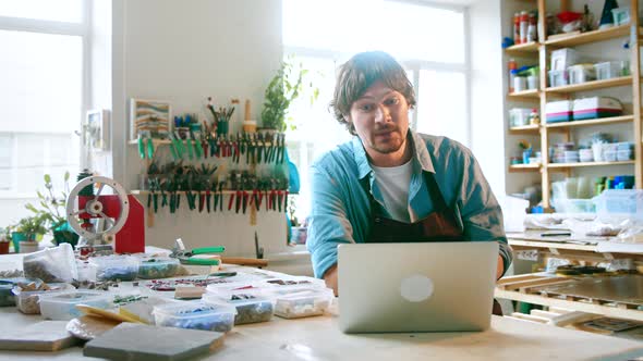 Smiling man in uniform with laptop alt