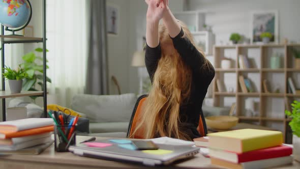 Young Beautiful Woman Emotionally Singing a Song and Dancing While Sitting at a Writing Table at alt