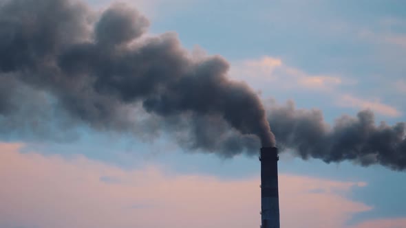 Pipe with smoke from industrial production polluting the air. alt