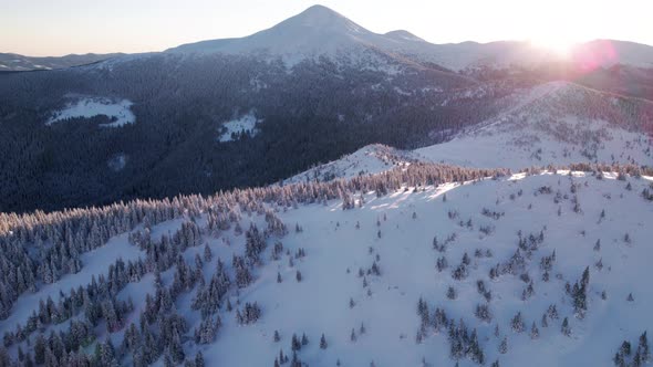 Aerial Revealing Shot of Summit Covered in Snow at Sunrise