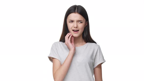 Portrait of Pretty Teen Woman with Long Hair Suffering From Toothache and Touching Cheek with Pain alt