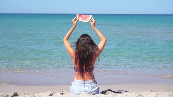 Happy Girl Having Fun on the Beach and Eating Watermelon