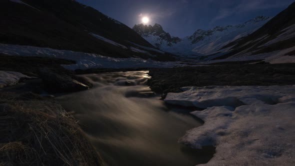 Time-lapse of Moon, Mountain Valley and River. Moonrise. Snow-capped Mountains 