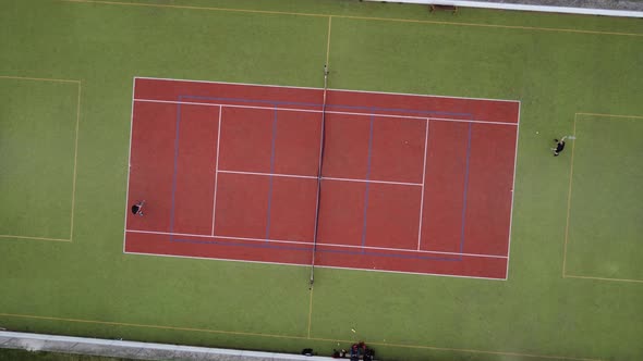 An Artificial Tennis Court Seen From Above with Two Men Playing a Match