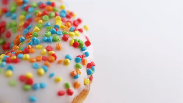 Sprinkled Sweet Donut Rotating at White Background with Copy Space alt