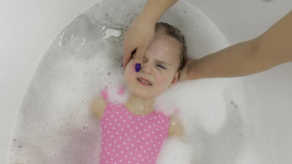Cute Blonde Girl Takes A Bath In Swimwear Little Child Washes Her Head