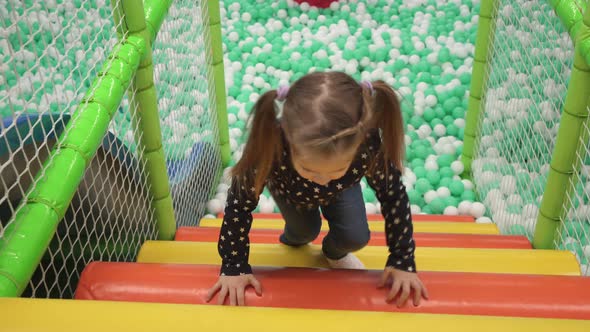 Child Climbs Stairs on Playground in Children's Center