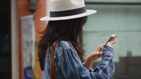 Beautiful Asian girl using smartphone at community mall.