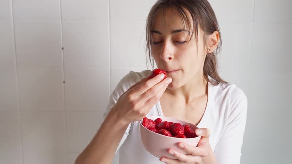 Woman Holds Bowl with Strawberry and Eats Berries alt