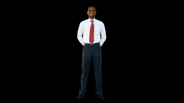 Businessman standing and smiling against black background alt