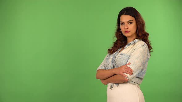 A Young Beautiful Caucasian Woman Looks Seriously at the Camera  Green Screen Background