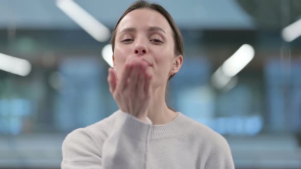 Portrait of Woman giving Flying Kiss by Hands alt