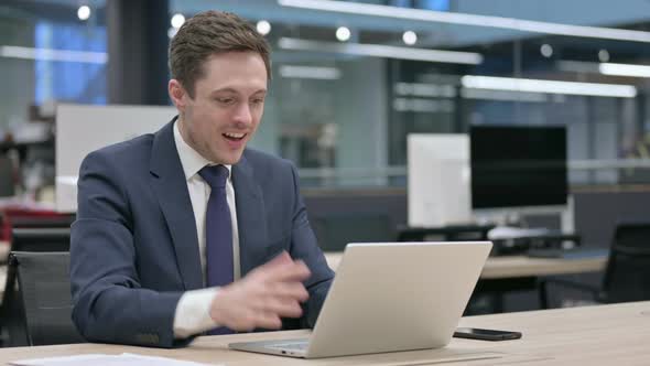 Businessman Celebrating Success While Using Laptop in Office alt