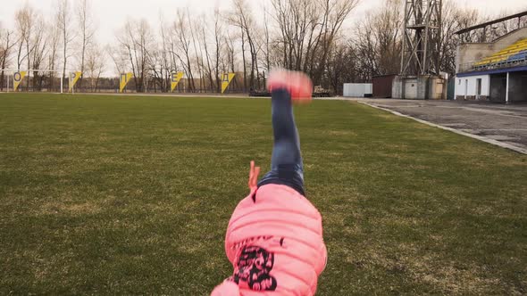 Active Little Girl Doing Cartwheel on Green Grass