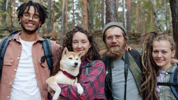 Slow Motion Portrait of Male and Female Friends with Dog Standing Outside in Summer Forest alt