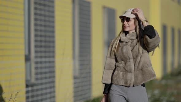 Rich Woman Dressed Luxury Fur Jacket and Cap Is Walking Outdoors at Sunny Day Fashionista in Big alt