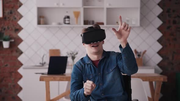 Adult Man in Wheelchair Using Vr Helmet at Home. Male or Teenager Wearing VR Goggles. Concept