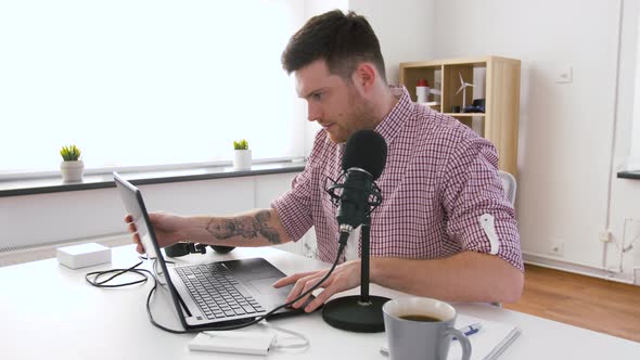 Man in Headphones with Laptop Speaks To Microphone 57 alt